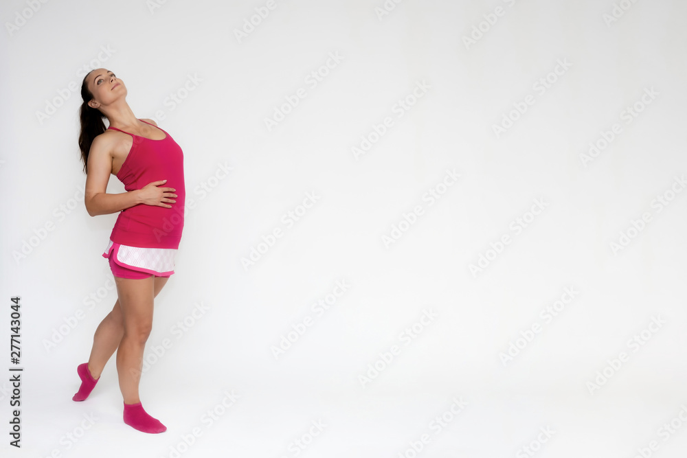 Full-length portrait on white background of beautiful pretty fitness girl woman in pink sport uniform standing exercises in different poses with different emotions. Smiles Stylish trendy youth. Full-length portrait on white background of beautiful pretty fitness girl woman in pink sport uniform standing exercises in different poses with different emotions. Smiles Stylish trendy youth.