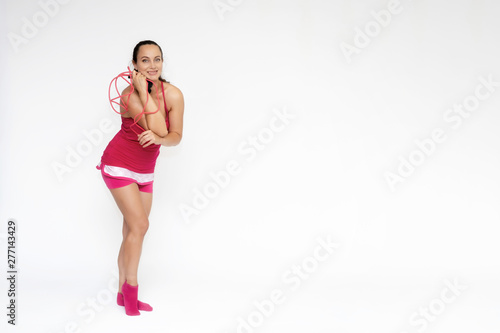 Full-length portrait on white background of beautiful pretty fitness girl woman in pink sport uniform standing exercises in different poses with a skipping rope. Smiles Stylish trendy youth. © Вячеслав Чичаев