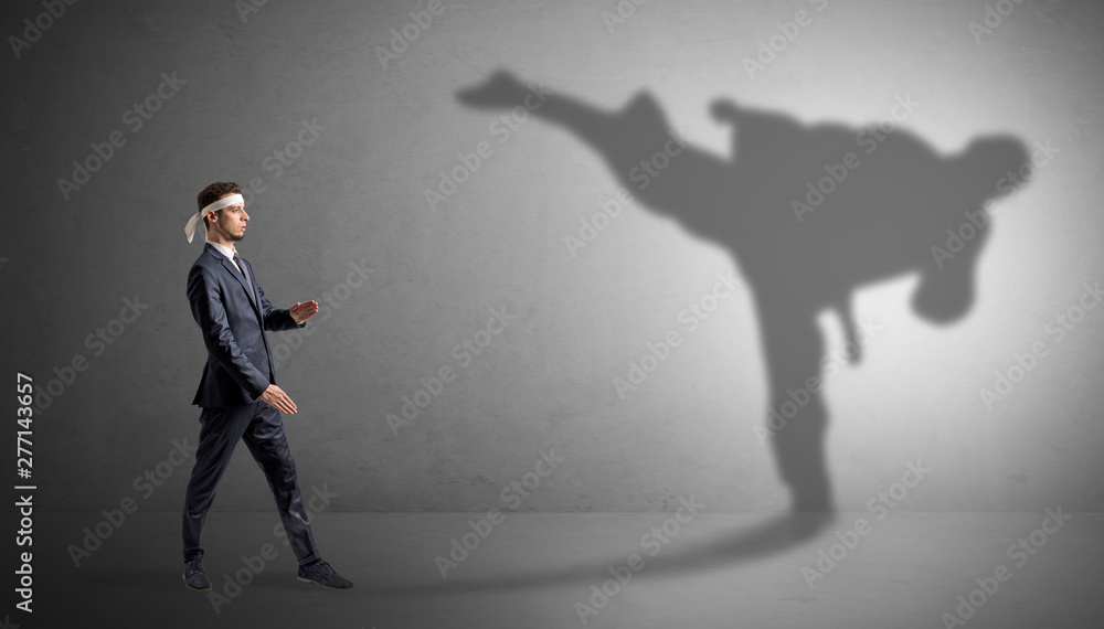 Young karate man confronting with his own shadow Young karate man confronting with his own shadow