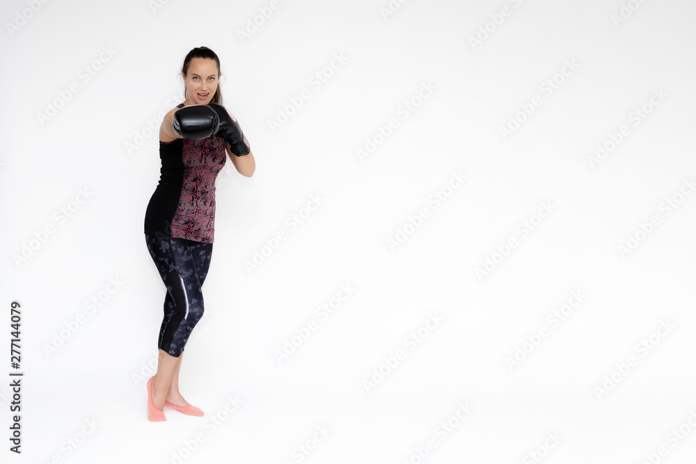 Full-length portrait on white background of beautiful pretty fitness woman girl in fashionable sportswear standing exercising in different poses with boxing gloves. Smiles Stylish trendy youth. Full-length portrait on white background of beautiful pretty fitness woman girl in fashionable sportswear standing exercising in different poses with boxing gloves. Smiles Stylish trendy youth.