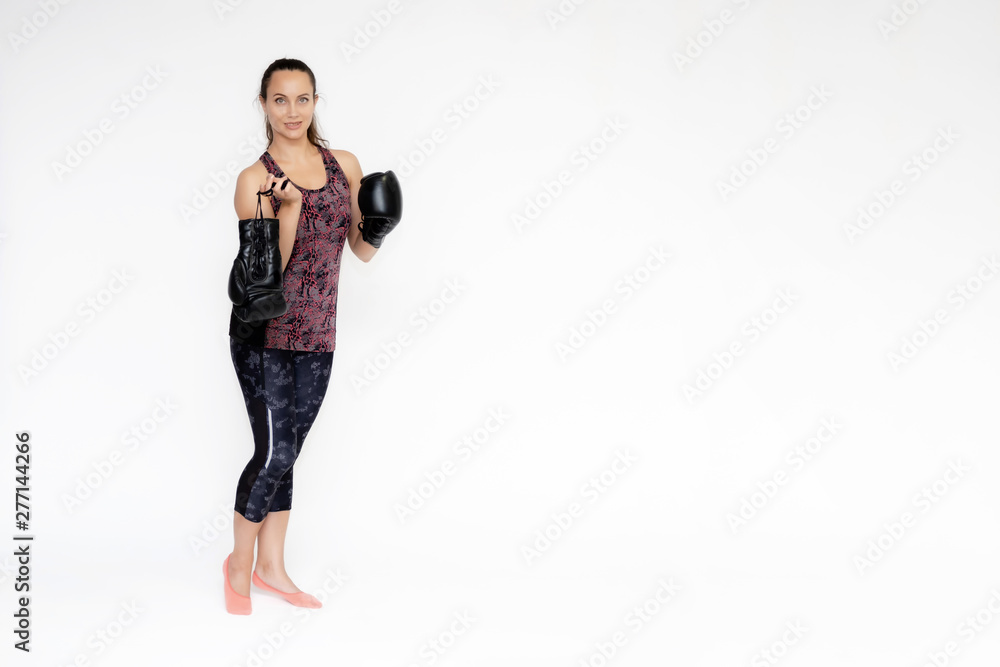Full-length portrait on white background of beautiful pretty fitness woman girl in fashionable sportswear standing exercising in different poses with boxing gloves. Smiles Stylish trendy youth. Full-length portrait on white background of beautiful pretty fitness woman girl in fashionable sportswear standing exercising in different poses with boxing gloves. Smiles Stylish trendy youth.