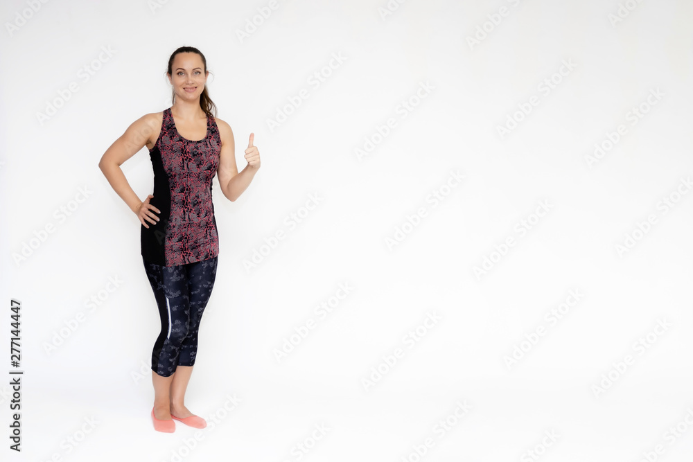Full-length portrait on white background of beautiful pretty fitness woman girl in fashionable sportswear standing exercising in different poses, showing hands. Smiles Stylish trendy youth. Full-length portrait on white background of beautiful pretty fitness woman girl in fashionable sportswear standing exercising in different poses, showing hands. Smiles Stylish trendy youth.