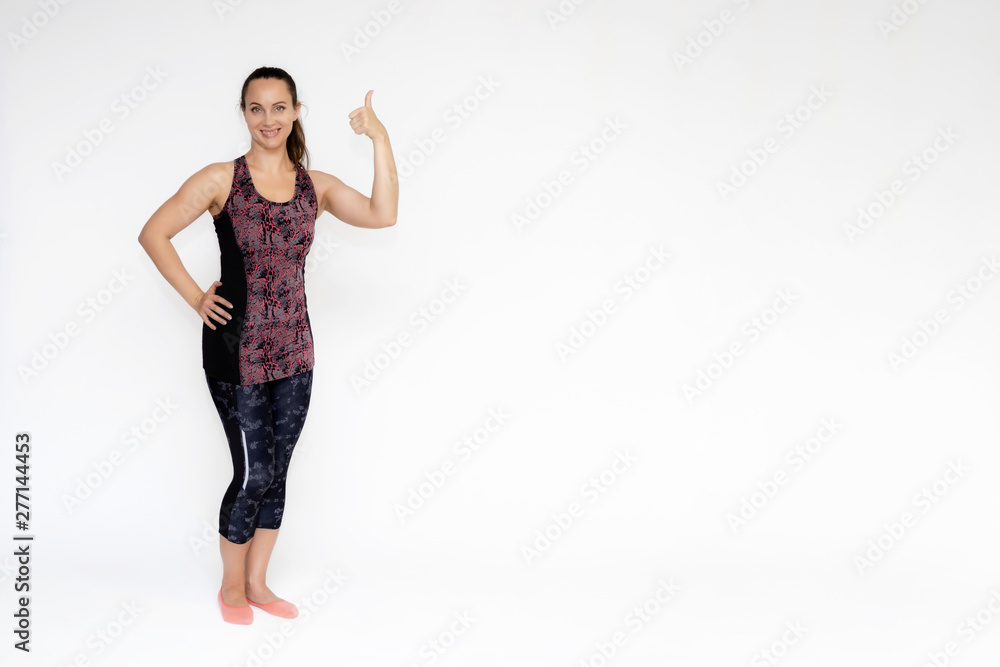 Full-length portrait on white background of beautiful pretty fitness woman girl in fashionable sportswear standing exercising in different poses, showing hands. Smiles Stylish trendy youth. Full-length portrait on white background of beautiful pretty fitness woman girl in fashionable sportswear standing exercising in different poses, showing hands. Smiles Stylish trendy youth.