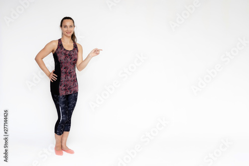 Fototapeta Naklejka Na Ścianę i Meble -  Full-length portrait on white background of beautiful pretty fitness woman girl in fashionable sportswear standing exercising in different poses, showing hands. Smiles Stylish trendy youth.