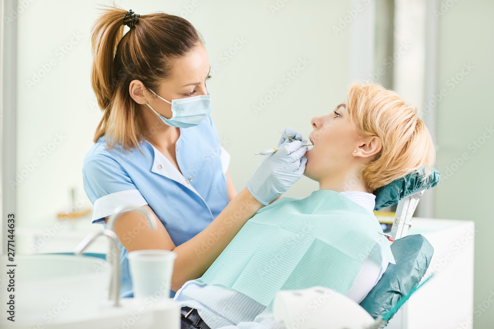 Dentist checks the teeth of a girl in the dental office Dentist checks the teeth of a girl in the dental office