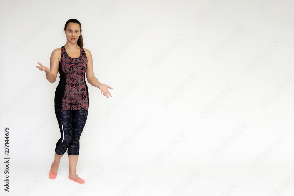Full-length portrait on white background of beautiful pretty fitness woman girl in fashionable sportswear standing exercising in different poses, showing hands. Smiles Stylish trendy youth. Full-length portrait on white background of beautiful pretty fitness woman girl in fashionable sportswear standing exercising in different poses, showing hands. Smiles Stylish trendy youth.