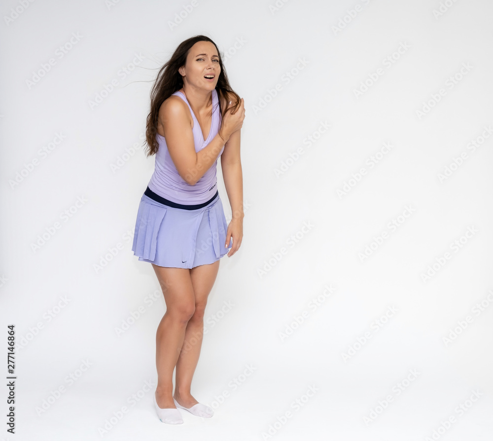Full-length portrait on white background of beautiful pretty fitness girl woman in fashionable tennis sportswear, experiencing pain, injury in various poses, shows hands. Smiles Stylish trendy youth. Full-length portrait on white background of beautiful pretty fitness girl woman in fashionable tennis sportswear, experiencing pain, injury in various poses, shows hands. Smiles Stylish trendy youth.
