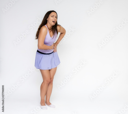 Full-length portrait on white background of beautiful pretty fitness girl woman in fashionable tennis sportswear, experiencing pain, injury in various poses, shows hands. Smiles Stylish trendy youth.