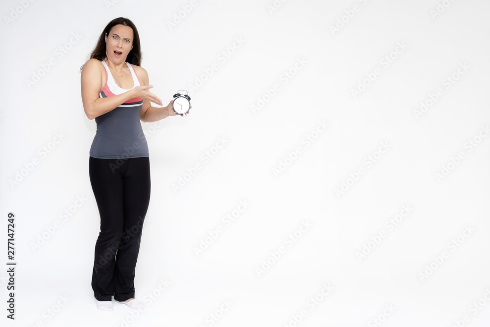Full-length portrait on white background of beautiful pretty fitness girl woman in sports uniform with a clock in her hands, stands with different emotions in different poses. Stylish trendy youth. Full-length portrait on white background of beautiful pretty fitness girl woman in sports uniform with a clock in her hands, stands with different emotions in different poses. Stylish trendy youth.