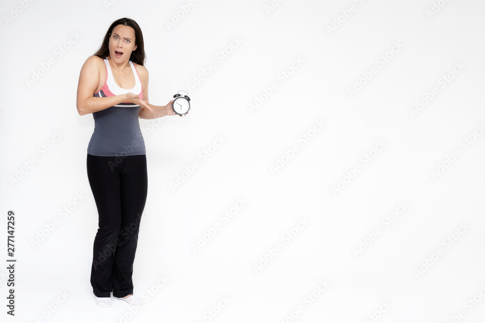 Full-length portrait on white background of beautiful pretty fitness girl woman in sports uniform with a clock in her hands, stands with different emotions in different poses. Stylish trendy youth.
