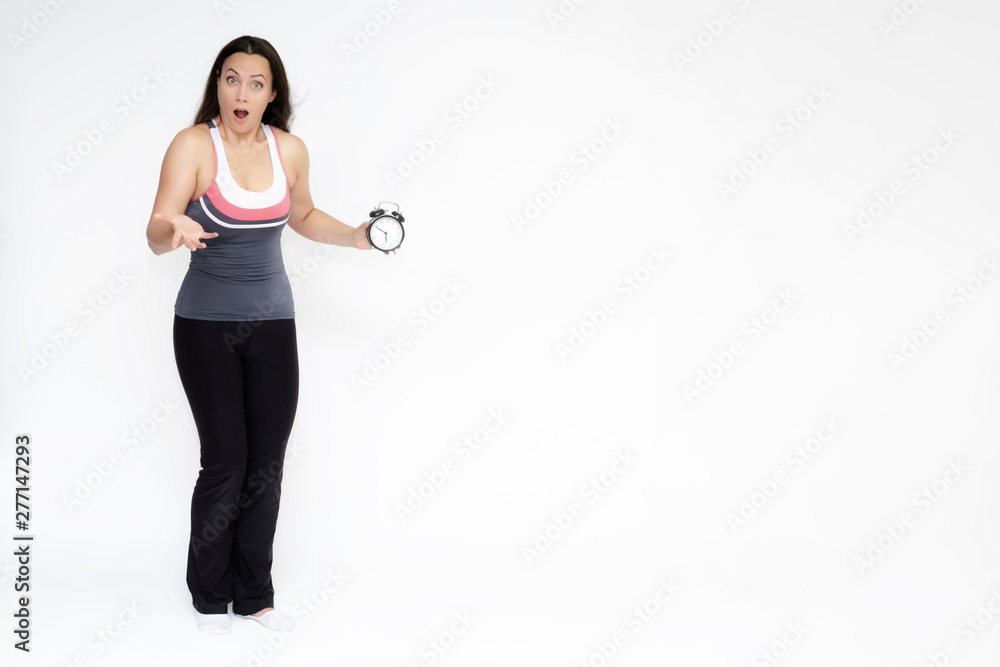 Full-length portrait on white background of beautiful pretty fitness girl woman in sports uniform with a clock in her hands, stands with different emotions in different poses. Stylish trendy youth. Full-length portrait on white background of beautiful pretty fitness girl woman in sports uniform with a clock in her hands, stands with different emotions in different poses. Stylish trendy youth.