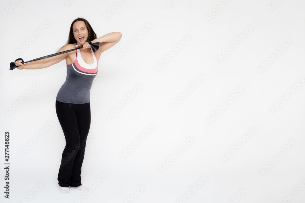Full-length portrait on white background of beautiful pretty fitness girl woman in sports uniform with rubber expander in hands, with different emotions in different poses. Stylish trendy youth. Full-length portrait on white background of beautiful pretty fitness girl woman in sports uniform with rubber expander in hands, with different emotions in different poses. Stylish trendy youth.