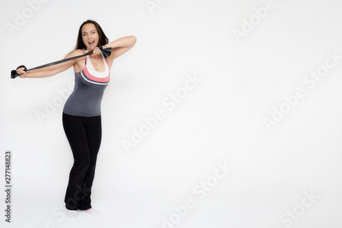 Full-length portrait on white background of beautiful pretty fitness girl woman in sports uniform with rubber expander in hands, with different emotions in different poses. Stylish trendy youth. © Вячеслав Чичаев