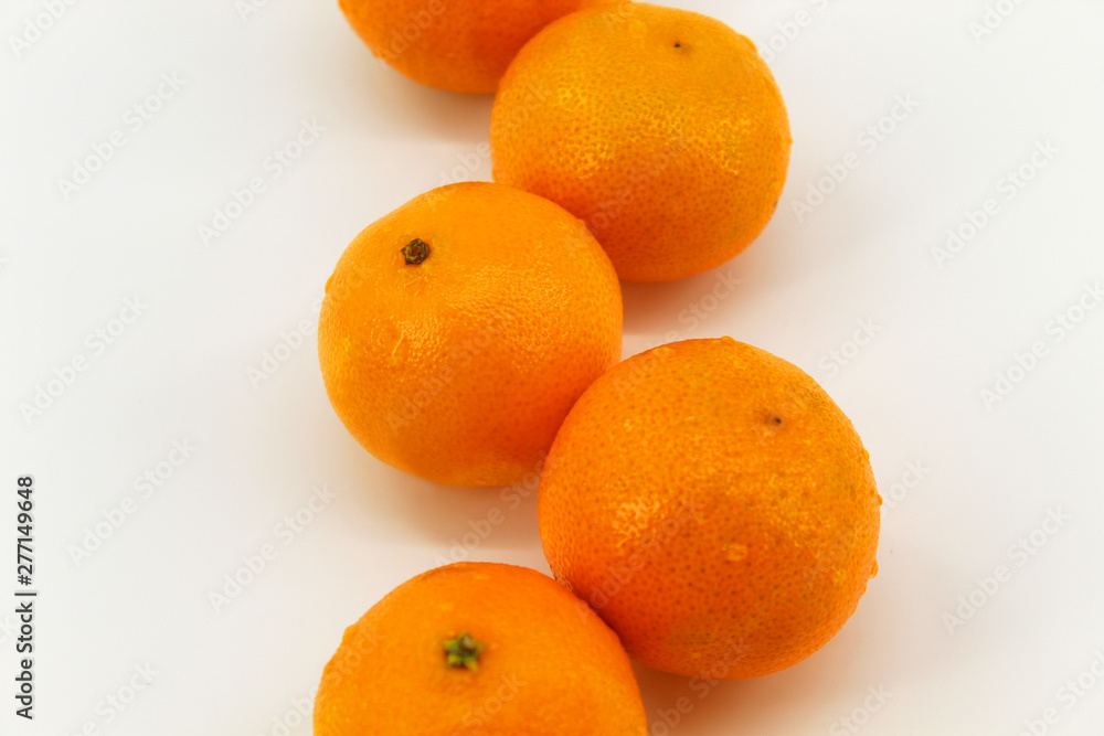 On a light background is a little fruit, orange, tangerines On a light background is a little fruit, orange, tangerines