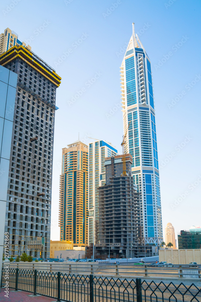 Dubai marina skyscrapers at sunset. View against of blue sky from the Amaar walk. Apartments, hotels and office buildings of UAE