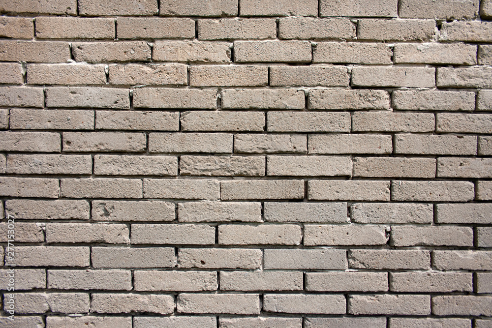 An old, damaged wall of gray bricks - a wabi-sabi style background