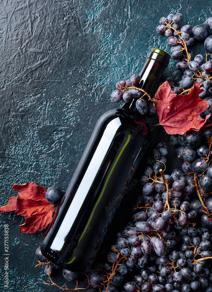 Bottle of red wine and grapes. - obrazy, fototapety, plakaty 
