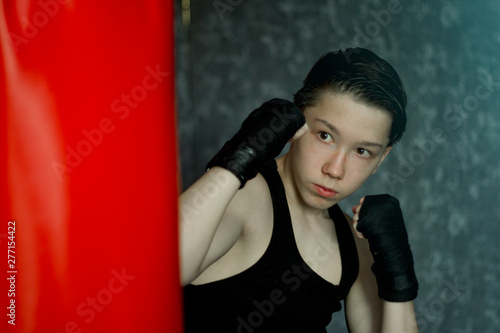 A teenager in a black t-shirt in Boxing training. © andreysha74