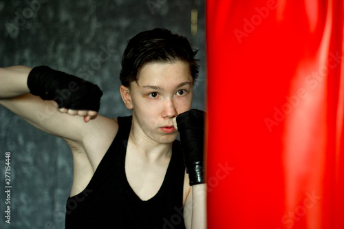 A teenager in a black t-shirt in Boxing training. © andreysha74