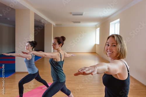 A group of young women performs yoga asanas