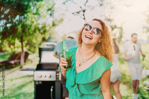 Portrait of smiling woman having a drink with friends at garden party