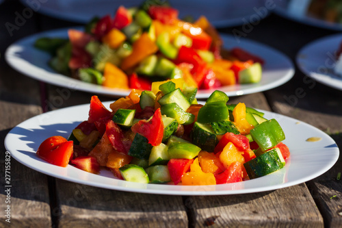 bowl of salad with vegetables and greens on wooden table