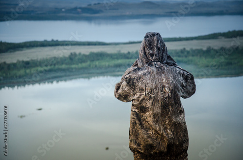 traveler hunter looks at mountain lake twilight landscape