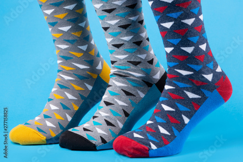 three legs in colorful socks with an interesting design, concept