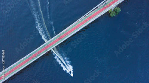 Aerial view Bridge, a landmark . Variety of high speed boat, yacht, jet ski on Colorado River and car traffic. Top of Town Lake and Hill Country landscape. Panorama