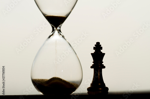 Chess pieces and hourglass, accumulation of time