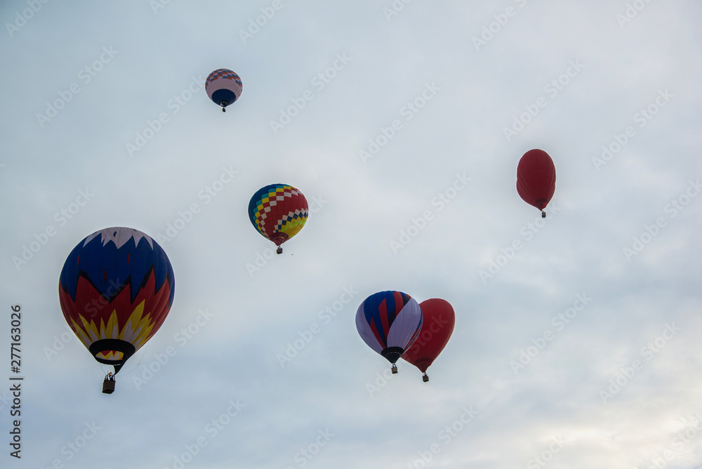 Multicolored hot air balloons on a blue cloudy sky