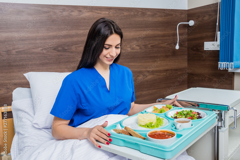 Tray with breakfast for the young female patient. The young woman eating in the hospital. Tray with breakfast for the young female patient. The young woman eating in the hospital.