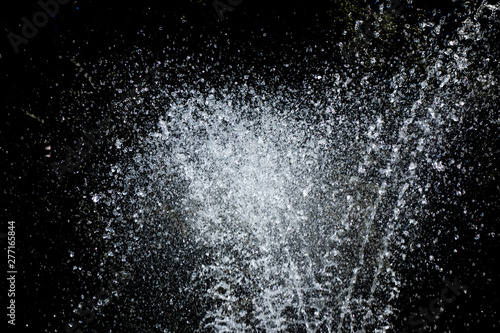 Water sprays and splashes on black background. Jets and drops of fountain isolated image