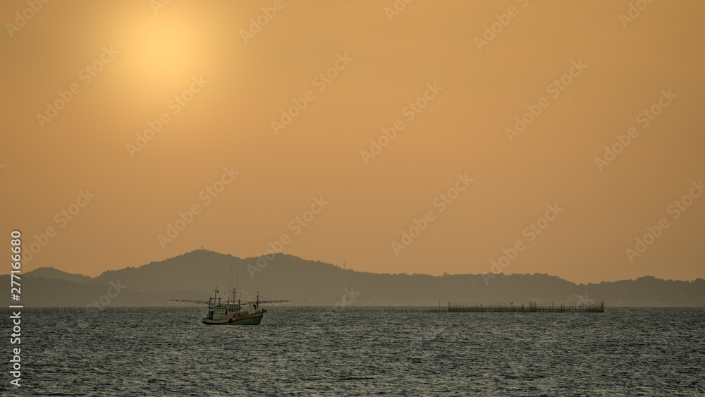 Fisherman boat in the sea with sunset sky