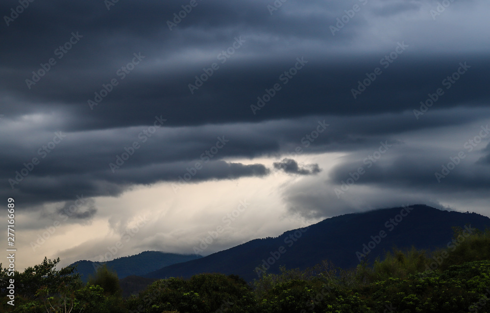 Scenery of black thunderstorm cloudy sky with forest and mountains. Scenery of black thunderstorm cloudy sky with forest and mountains.