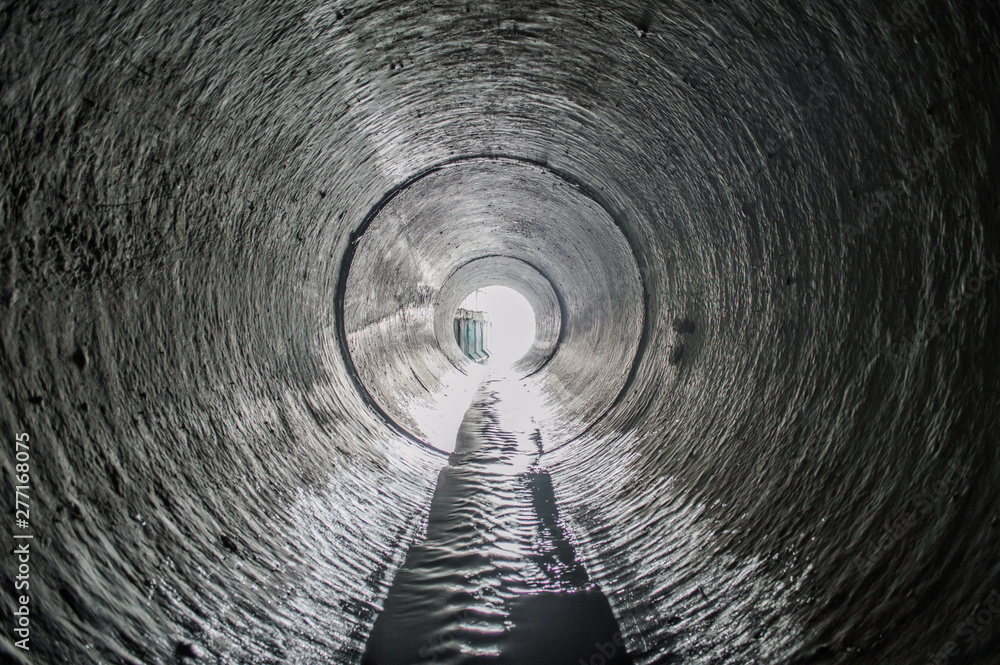 Naklejka premium Wyjście z rury drenażowej tunelu kanalizacyjnego. Rura drenarska betonowa, kolektor kanalizacji miejskiej