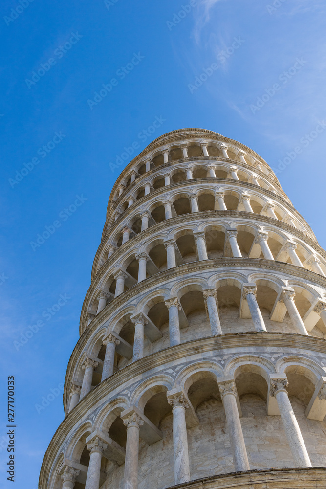 Looking up to the top of the leaning tower of Pisa, in the nbeautful tuscany. sunny day with blue sky at this famous italian landmark.