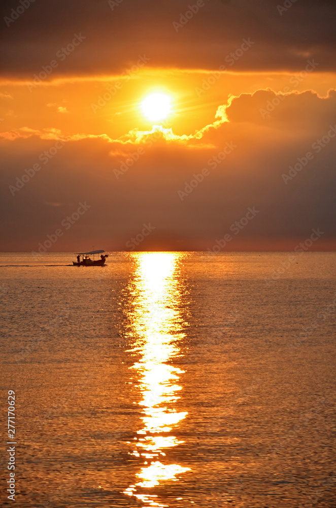 A fishing boat sailing on the sea at sunrise