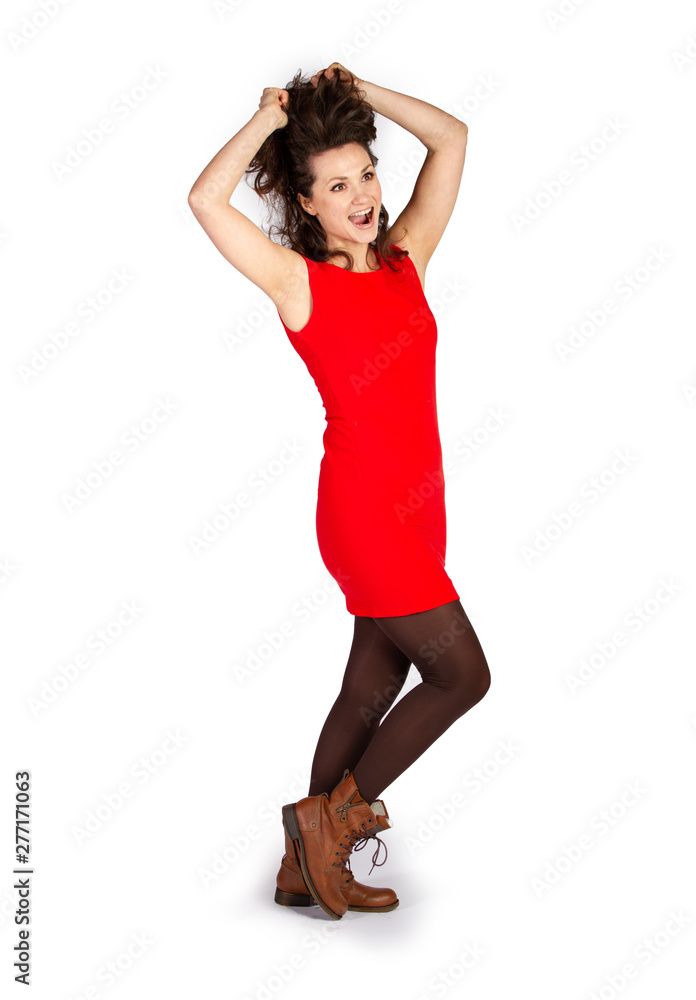 Fototapeta premium Freudige Frau im roten Kleid greift sich in Haare