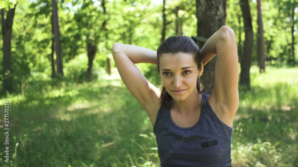 4K.Prettyyoung sporty woman doing exercises with TRX outdoors in city park or wood. Steady shot 4K.Prettyyoung sporty woman doing exercises with TRX outdoors in city park or wood. Steady shot