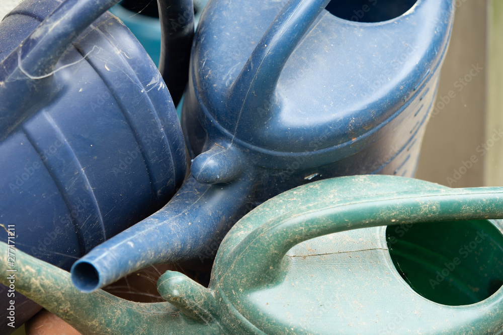Many dirty watering cans criss-cross each other Many dirty watering cans criss-cross each other