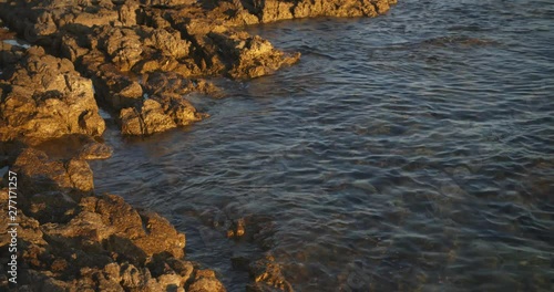 Rocks lapped by the sea on the Croatian Adriatic coast at sundown