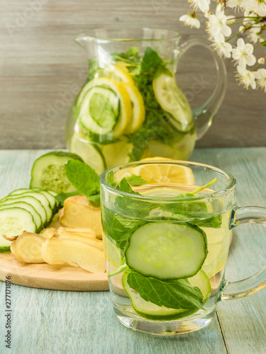 Cold summer drink of ginger, cucumber, mint and lemon in a jug and glass - Cool detox.