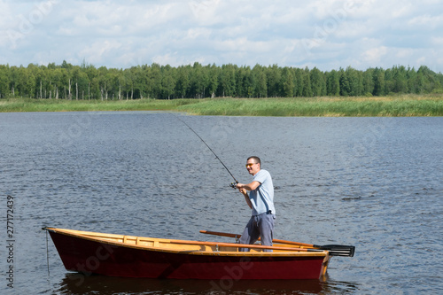 man in a boat fishing on a river in the forest