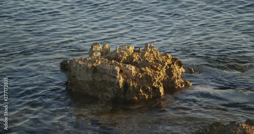 Rocks lapped by the sea on the Croatian Adriatic coast at sundown
