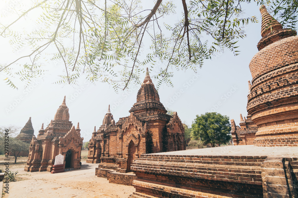 View over stupas and pagodas of ancient Bagan temple complex during sunrise golden hour in Myanmar