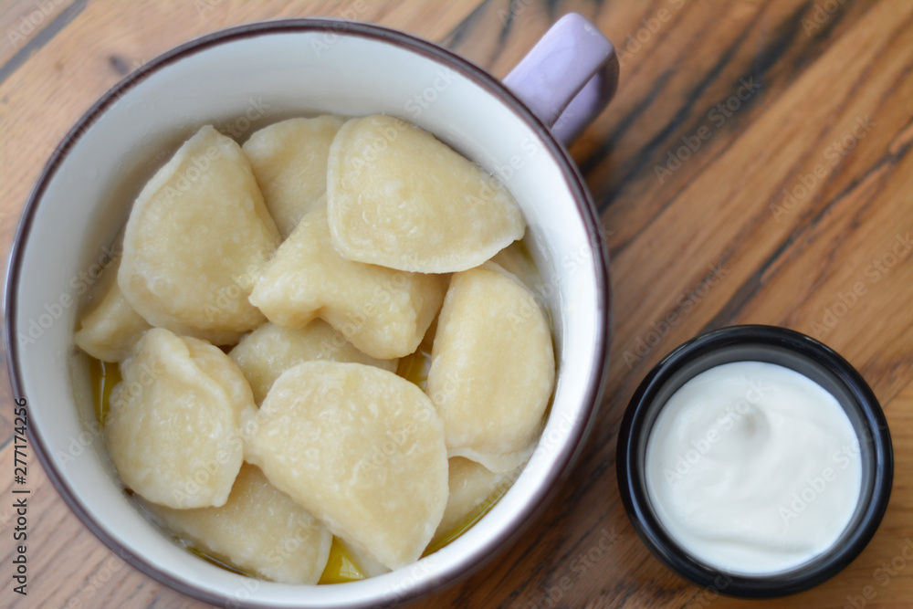 Вoiled dough and sour cream in an enamel bowl on the table Вoiled dough and sour cream in an enamel bowl on the table