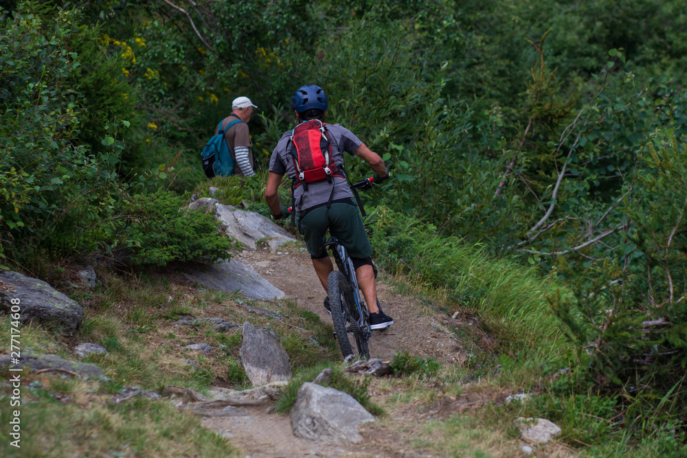 Obraz premium Cyclist in Red Riding the Bike on the Autumn Rocky Trail at Sunset. Extreme Sport and Enduro Biking Concept