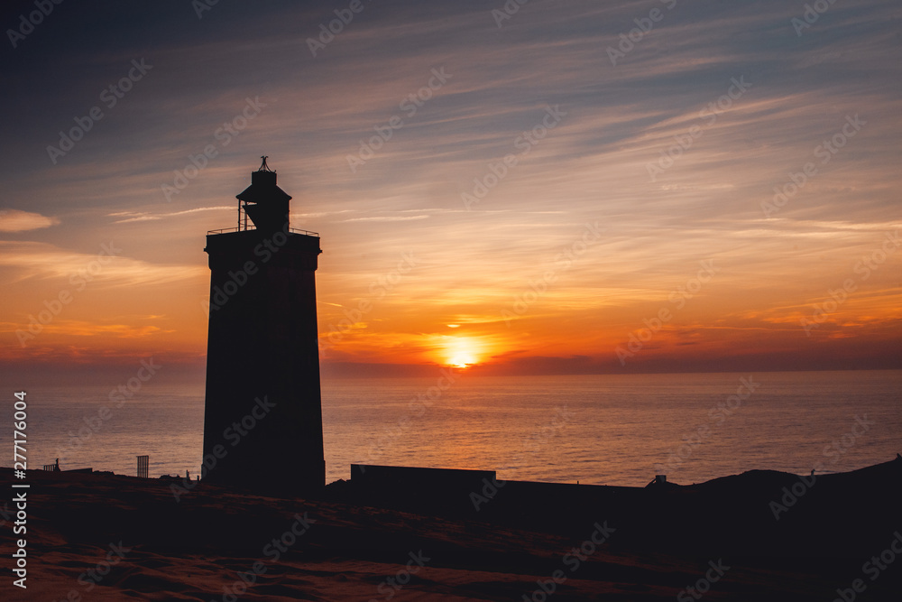 Silhouette of the famous danish lighthouse in the dunes with ocean view at colorful sunset light. Rubjerg Knude Lighthouse, Lønstrup in North Jutland in Denmark, Skagerrak, North Sea
