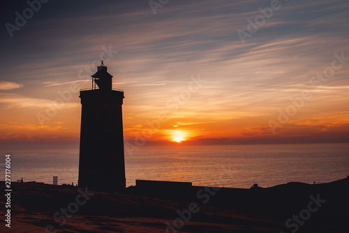 Silhouette of the famous danish lighthouse in the dunes with ocean view at colorful sunset light. Rubjerg Knude Lighthouse, Lønstrup in North Jutland in Denmark, Skagerrak, North Sea